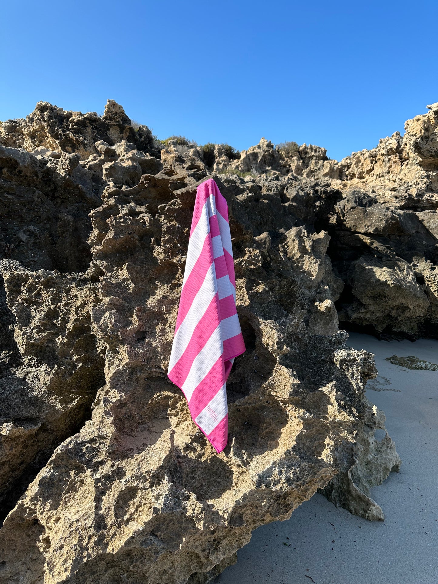 Kids size sand-free beach towel in pink colour, made from recycled materials for eco-conscious beachgoers. Our minimalist design towels are quick-dry, ultra-absorbent, lightweight and compact, and come in a convenient neoprene water resistant pouch for easy transport or storing your sunnies, keys etc. while enjoying the outdoors.