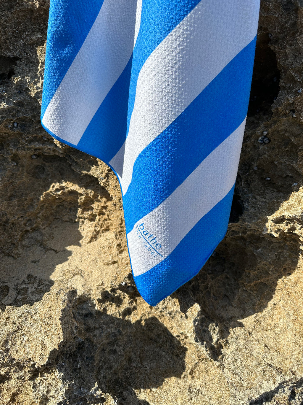 Kids size sand-free beach towel in blue colour, made from recycled materials for eco-conscious beachgoers. Our minimalist design towels are quick-dry, ultra-absorbent, lightweight and compact, and come in a convenient neoprene water resistant pouch for easy transport or storing your sunnies, keys etc. while enjoying the outdoors.